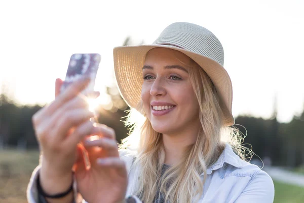 Vrouw nemen selfie buitenshuis — Stockfoto