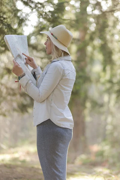 Exploradora feminina olhando para um mapa ao ar livre — Fotografia de Stock