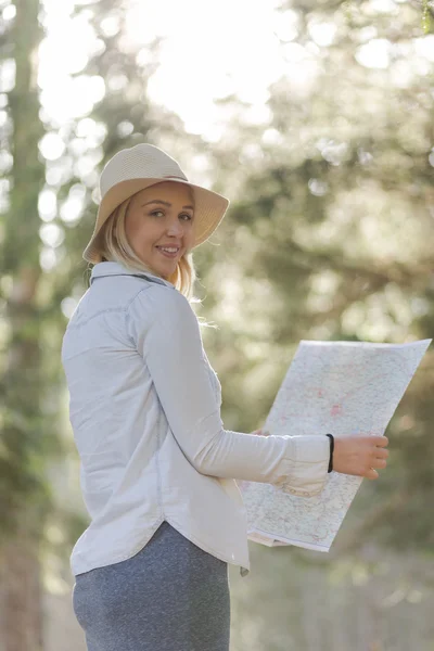 Exploradora feminina com um mapa nas mãos — Fotografia de Stock