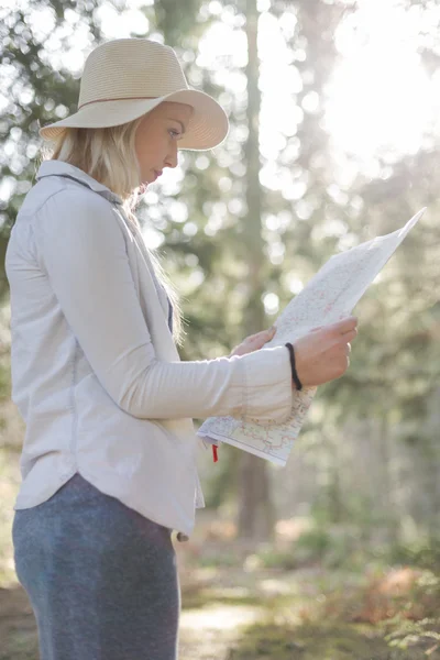 Exploradora feminina olhando para um mapa ao ar livre — Fotografia de Stock