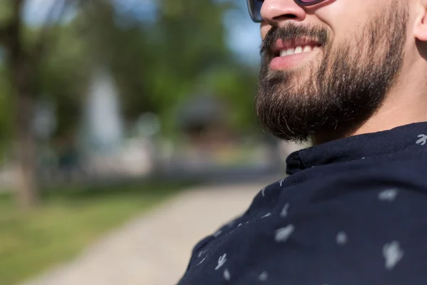 Hombre joven relajándose en el banco del parque — Foto de Stock