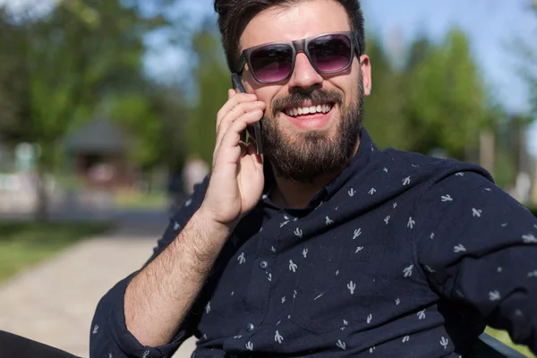 Joven barbudo hombre hablando en smartphone — Foto de Stock