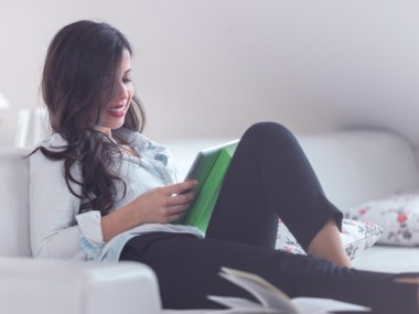 Kanepede tablet kullanan kadın.