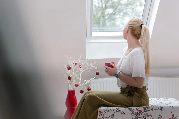 Mujer joven sosteniendo taza — Foto de Stock