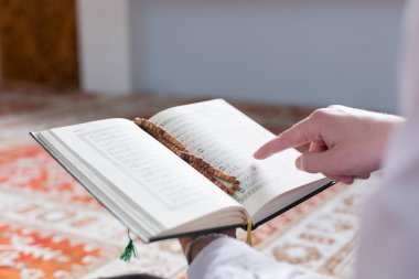 Müslüman adam Kuran okuyor.