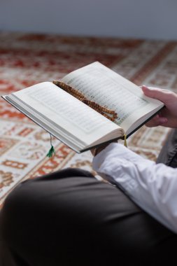 Müslüman adam Kuran okuyor.