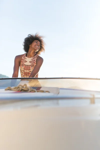 Una mujer afro increíblemente hermosa conduciendo una lancha rápida y teniendo —  Fotos de Stock