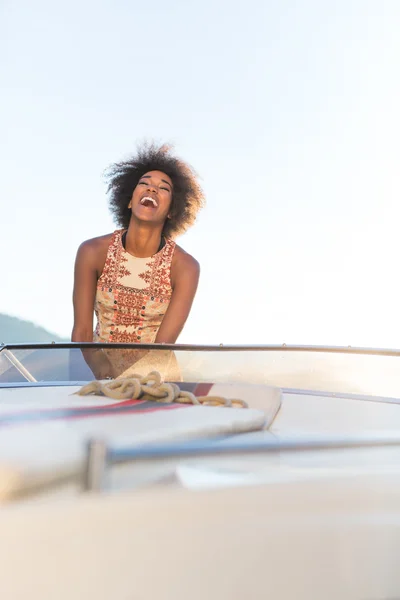 Vacaciones de verano - joven afro mujer conduciendo un barco a motor en el sol —  Fotos de Stock