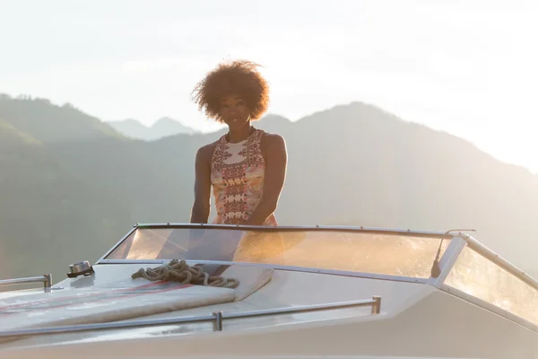 Летние каникулы - молодая женщина за рулем моторной лодки на закате — стоковое фото