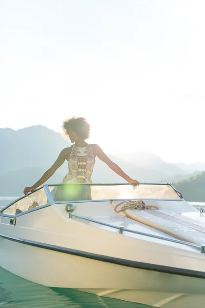 Vacaciones de verano - joven afro mujer conduciendo un barco a motor en el sol —  Fotos de Stock