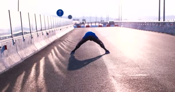 Man sträcker sig vid solnedgången — Stockvideo