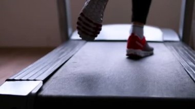 Bir koşu bandı üzerinde çalışan sporcu