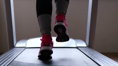 Bir koşu bandı üzerinde çalışan sporcu