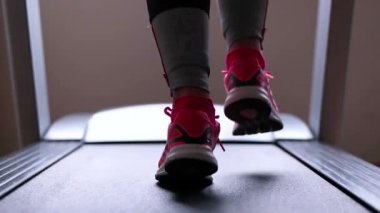 Bir koşu bandı üzerinde çalışan sporcu