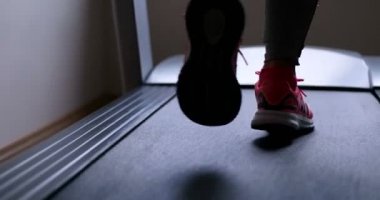 Bir koşu bandı üzerinde çalışan sporcu