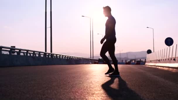 Man stretching at sunset — Stock Video