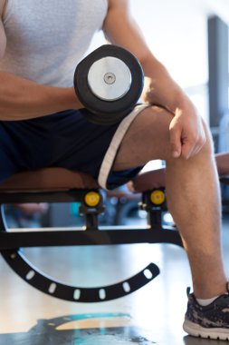 Adam dambılı kaldırıyor.