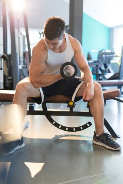 Adam dambılı kaldırıyor.