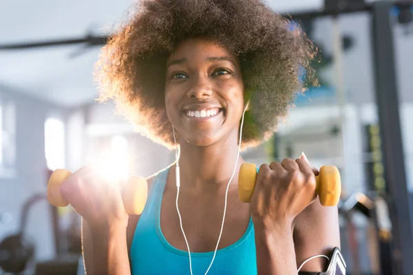 Frau trainiert im Fitnessstudio mit Hanteln — Stockfoto