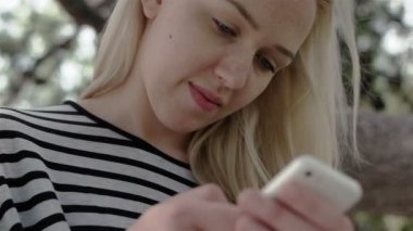 Sarışın kız telefonunu yazarak