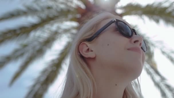 Chica disfrutando del verano bajo la palma de la mano — Vídeos de Stock