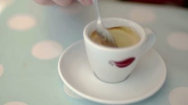 Caffe şık bir pastel arka planda yavaş karıştırma