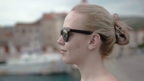 Chica turista rubia disfrutando del viento y mirando a su alrededor — Vídeos de Stock