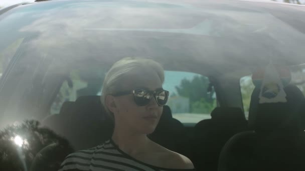 Mädchen macht ihr Haarbüschel im Auto, Reflexion auf der Scheibe eines Autos und Mädchen stylt ihr Haar — Stockvideo