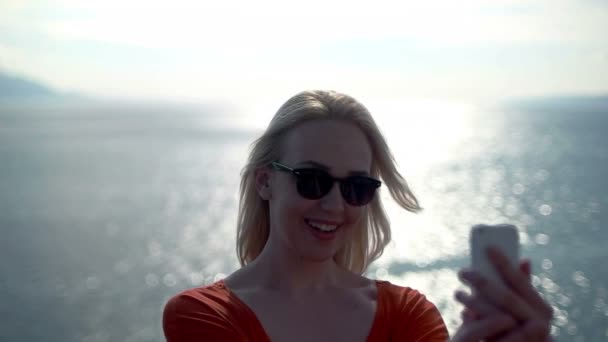 Chica tomando selfie al lado de la playa y sonriendo — Vídeo de stock