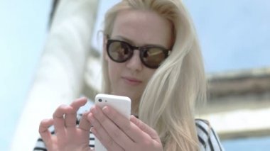 Sarışın kadın telefonunu yazarak