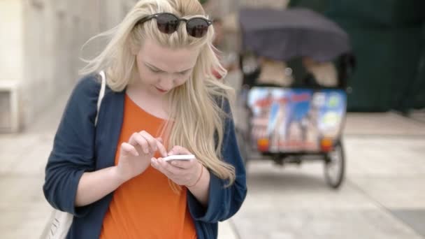 Turist blond kvinna söka något på telefon — Stockvideo