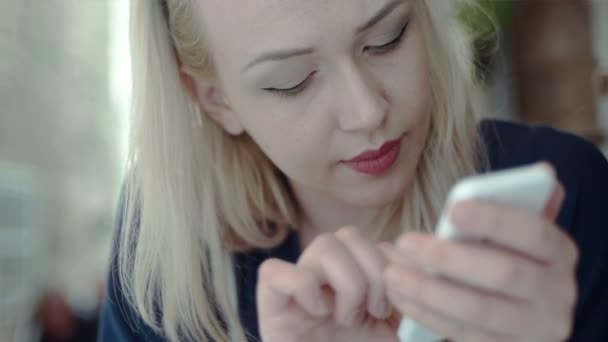 Blond kvinna att skriva på sin telefon — Stockvideo