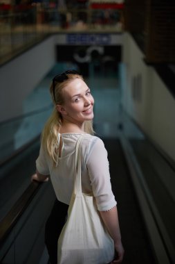 Merdivenlerden aşağı gidiş ve gülümseyen alışveriş sarışın kız