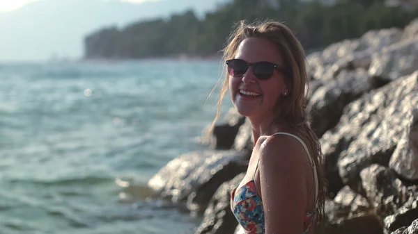 Mujer bonita de pie en el acantilado y disfrutando de las olas — Foto de Stock