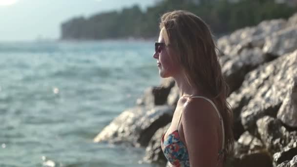 Ładna kobieta, stojący na klifie i ciesząc się fale — Wideo stockowe