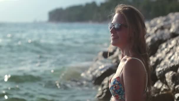 Όμορφη γυναίκα στέκεται στον απότομο βράχο και απολαμβάνοντας τα κύματα — Αρχείο Βίντεο