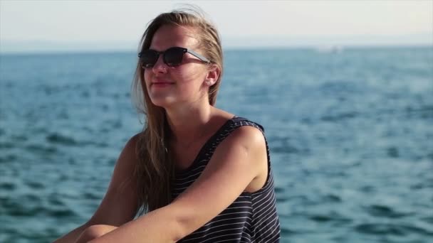 Chica de pie en el acantilado y salpicado de agua, Chica al lado del mar disfrutando del sol — Vídeos de Stock