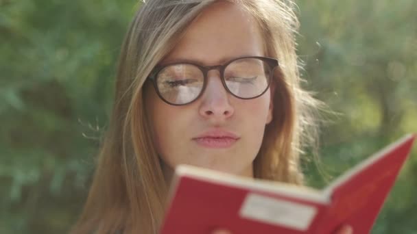 Chica leyendo libro fuera — Vídeos de Stock