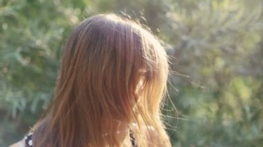 Gözlüklü inek kız güneşin tadını ve doğada gülümseyen güzel genç kız gülümseyerek kameraya gülümseyen kız