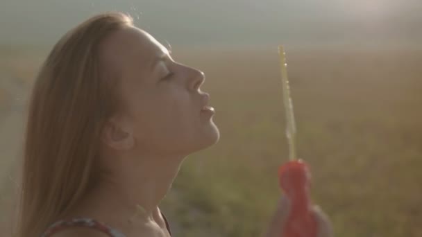 Девушка дует пузырьки в природе, красочные — стоковое видео