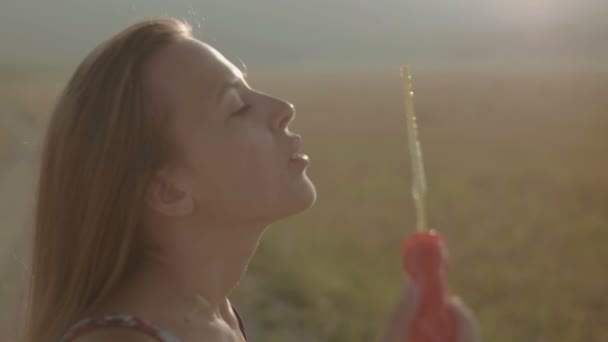 Chica Soplando burbujas en la naturaleza, colorido — Vídeo de stock