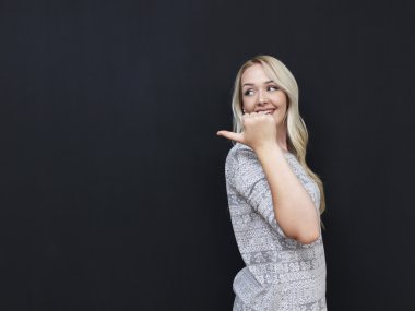 Parmak ile işaret kara tahta arka plan üzerinde güzel sarışın