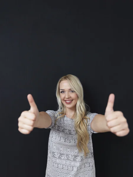 Söt blond kvinna på svarta tavlan bakgrund, visar som — Stockfoto