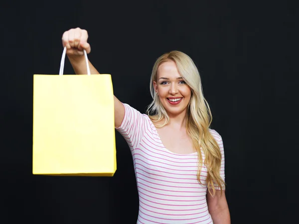 Blond meisje met boodschappentassen op een schoolbord achtergrond — Stockfoto