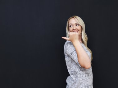 Karanlık yazı tahtası önünde duran beyaz kadın. Tebeşir kurulu bir ileti için bekleyen boş.