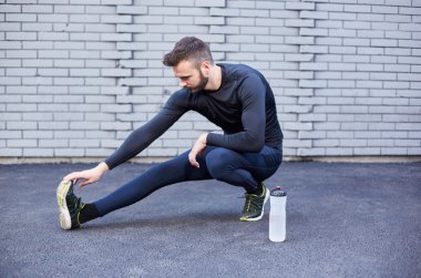 Beton duvara germe sakallı spor adam