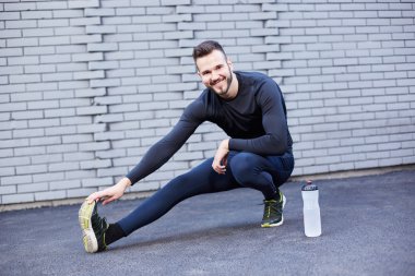 Beton duvara germe sakallı spor adam