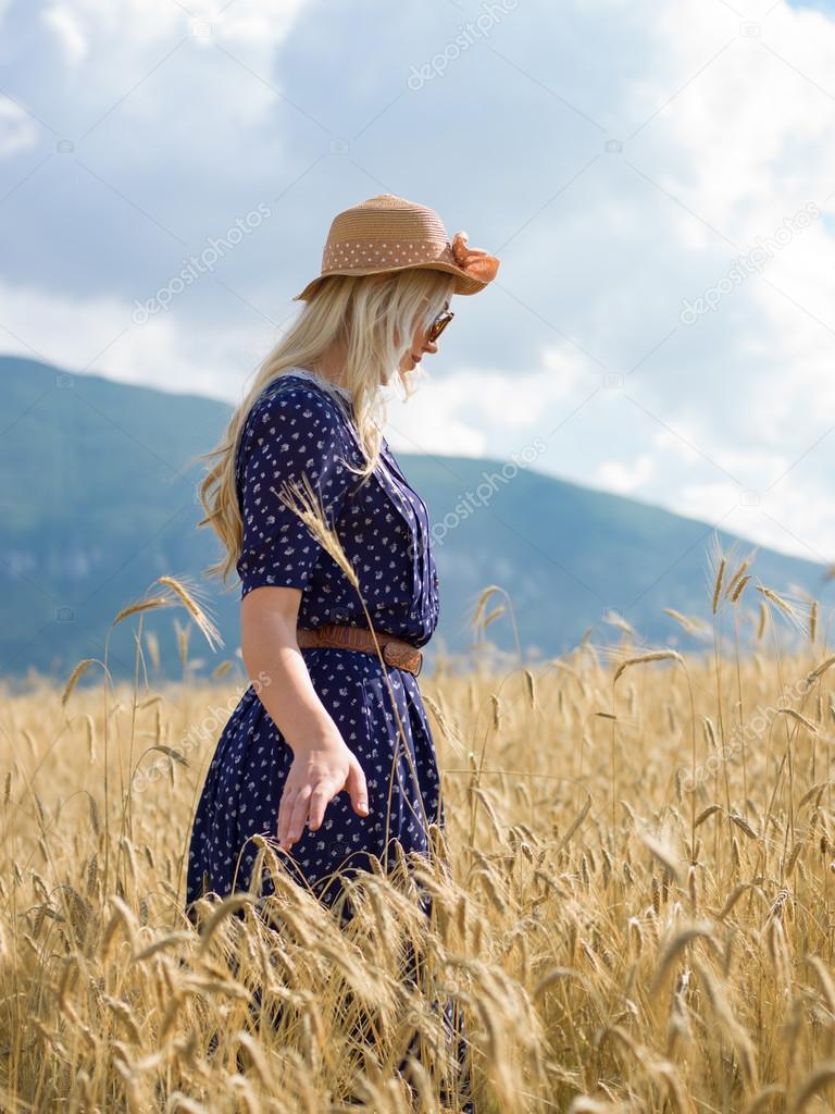 Romantic girl in a rural barley field. Summer, autumn life, freedom concept