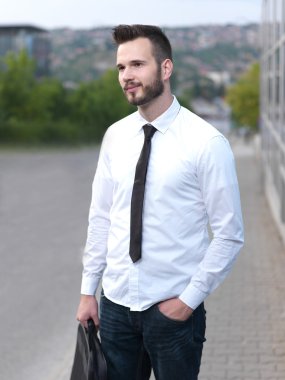 Samimi ve gülümseyen yakışıklı işadamı binanın önünde