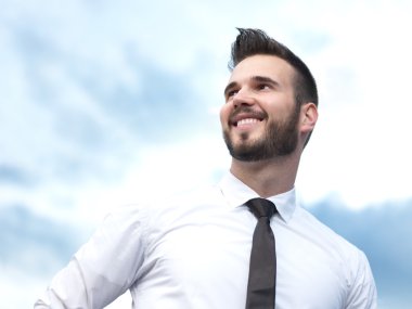 Samimi ve gülümseyen yakışıklı işadamı binanın önünde,